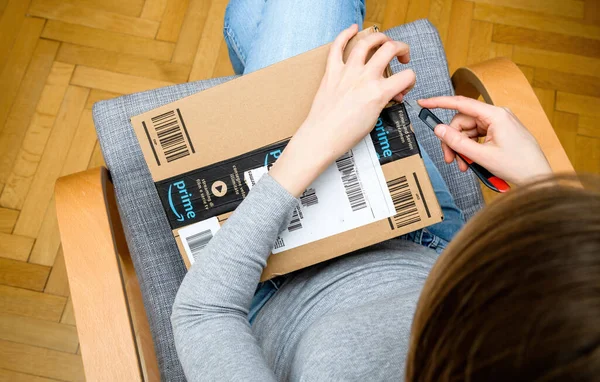 Vista aérea de la mujer curiosa unboxing en la sala de estar nuevo Amazon Prime Parcel — Foto de Stock