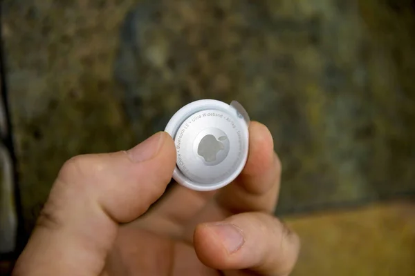Man pov holding new unboxed AirTag by Apple Computers — стокове фото