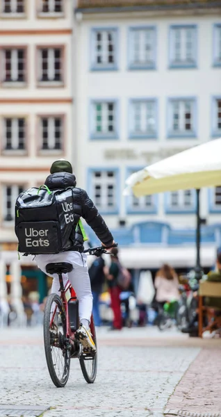 Treet scene - rear view of single biker self-employed worker with Uber Eats app — Stock Photo, Image