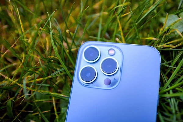 Close-up van de drie camera 's Apple Computers iPhone 13 pro in tuin gras achtergrond milieuvriendelijk — Stockfoto