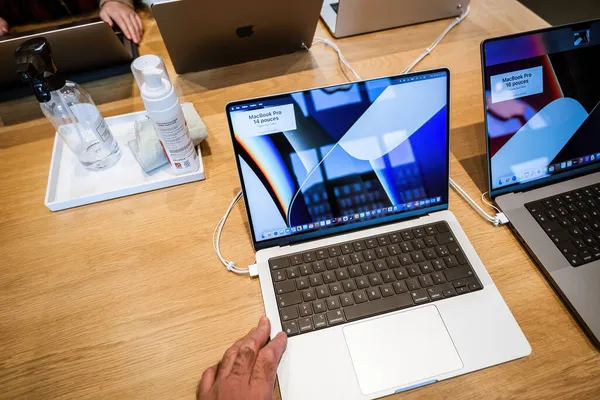 Homme testant à la main de nouveaux ordinateurs Apple MacBook Pro 16 pouces ordinateur portable doté d'un tout nouveau design avec plus de ports, pas de Touch Bar, MagSafe, M1 Pro et M1 Max puces, un écran mini-LED avec encoche de caméra — Photo