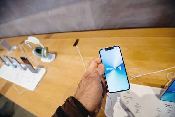 男子手握新iPhone 13迷你手机在苹果商店 — 图库照片