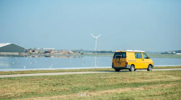 Жовтий автобус, який швидко їде біля водного каналу в Нідерландах. — стокове фото