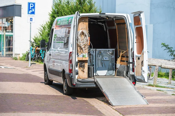 Vit elektrisk Volkswagen transportör van transporterar tvätt torktumlare och tvättmaskiner - stora hushållsapparater installation transport renovering — Stockfoto