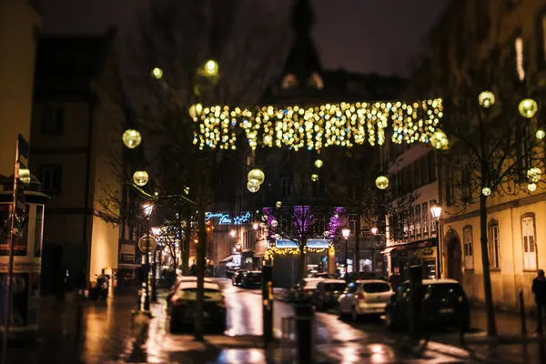 Gedeocaliseerde lege straat met kerstversieringen boven de straat en auto 's silhouetten geparkeerd - kantelverschuiving perspectief controle lens gebruikt — Stockfoto