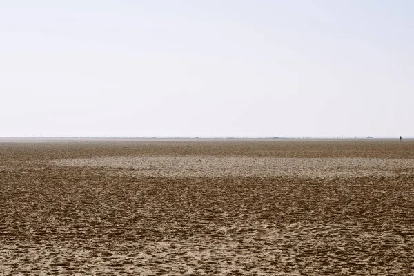 Lidská silueta na holandské manželky písečné duny pláž s městem v pozadí — Stock fotografie