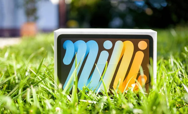 Cadeau in de tuin met hoog gras - kartonnen doos met nieuwe Apple Computers iPad Mini Pro — Stockfoto