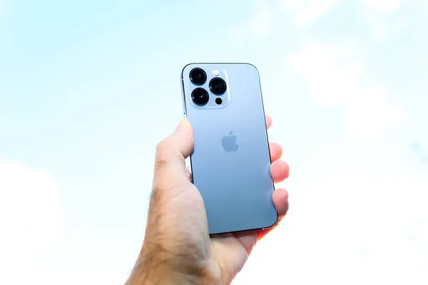 Apple Computers iPhone 13 pro with all three rear cameras and lidar sensor against blue sky — Stock Photo, Image