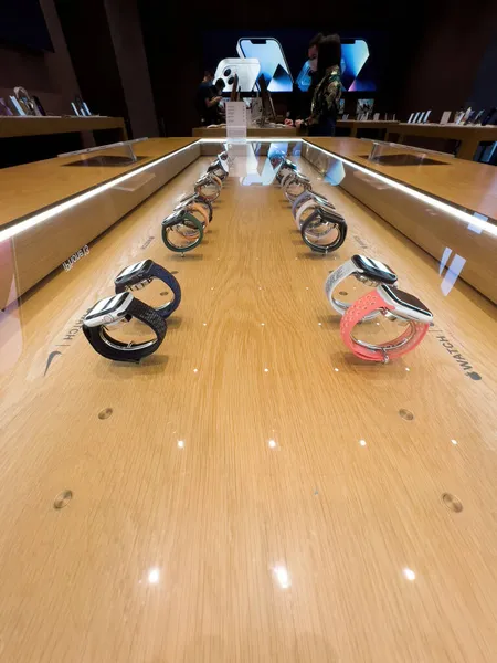 Row of entire collection of wearable computer Apple Watch Series 7 smartwatch with perspective view of Apple Store in background — Stock Photo, Image