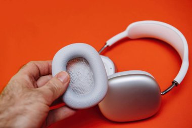 Yeni gümüş Apple Bilgisayarları için el ele tutuşan yastık. Kulaklıklar maksimum düzeyde.