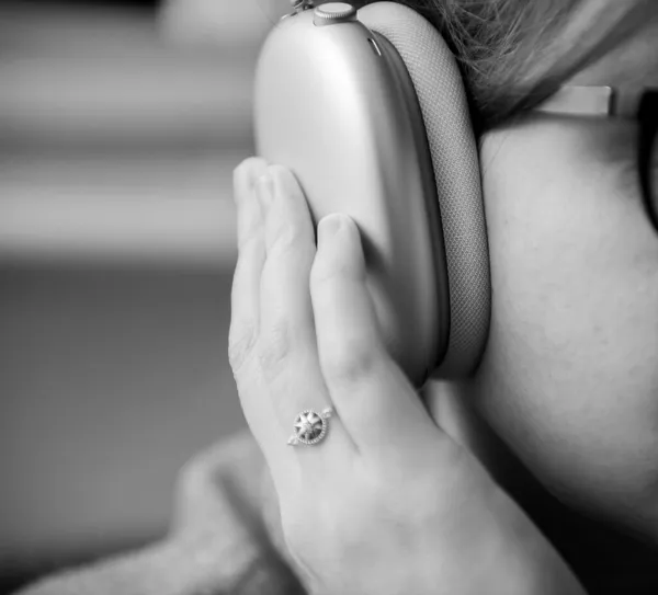 Mujer musicófilo disfruta escuchando nuevos Apple Computers AirPods Max auriculares sobre la oreja con ecualizador adaptable — Foto de Stock