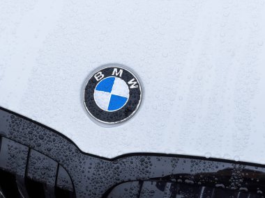 Yeni BMW Serisi 3 hibrit araba üzerindeki yağmur damlalarıyla kaplı logotype amblemlerinin ön görüntüsü