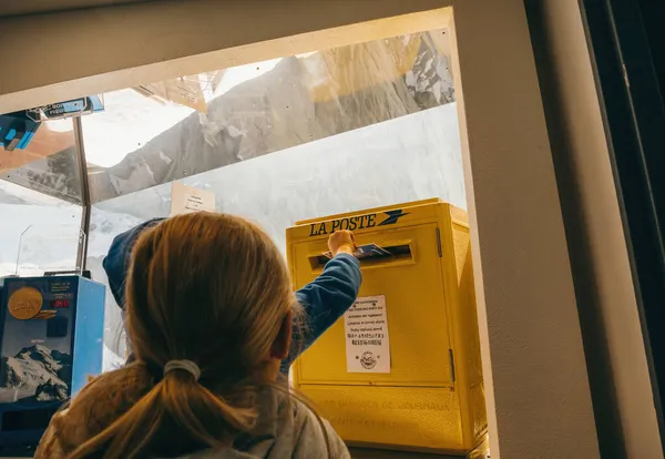 Young boy inserting greeting card in the La Poste mailbox — Stock Photo, Image