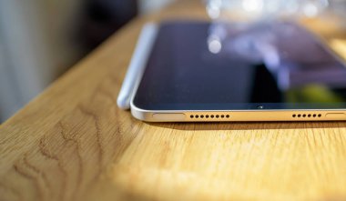 Apple Bilgisayarları iPad Mini tablet bilgisayarı ve dokunmatik kimliğe odaklı tahta masa üzerinde Apple kalem.