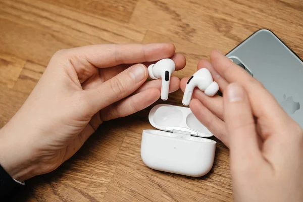 Vrouw houdt na het unboxen van nieuwe AirPods Pro draadloze Bluetooth in-ear hoofdtelefoon — Stockfoto