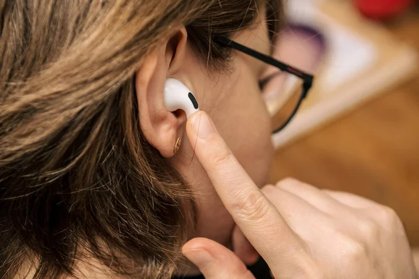 Woman changing volume pause with invisible buttons on the AirPods Pro wireless Bluetooth — Stock Photo, Image