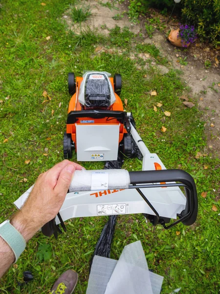POV male hand holding hands on the new professional Stihl lawn mower — стоковое фото