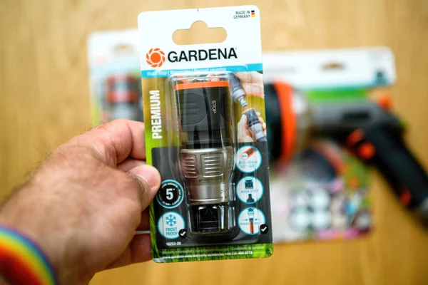 Mužská ruka drží nový Gardena Premium hadice konektor — Stock fotografie