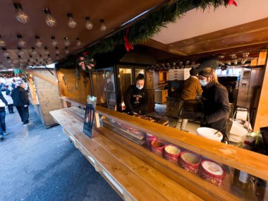 Solunum maskesi takan emale satıcısı COVID-19 hastalığı Coronavirus enfeksiyonuna karşı tarte flambee hazırlıyor.