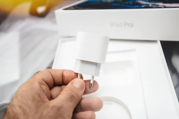 POV maschio mano che tiene il nuovo caricabatterie USB-c per il nuovo iPad pro — Foto Stock