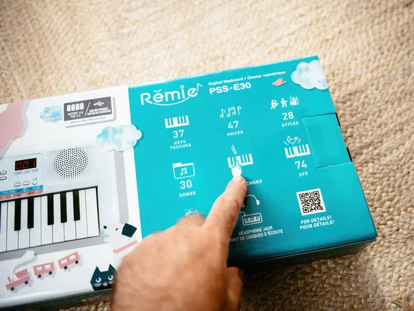 Mano masculina apuntando al acorde inteligente en el nuevo teclado digital Yamaha Remie PSS-E30 para niños con múltiples instrumentos — Foto de Stock