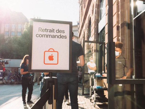 Sinal de luz solar Retrait des Commandes traduzido como pick-up de ordem de internet na frente da Apple Store em Place Kleber — Fotografia de Stock