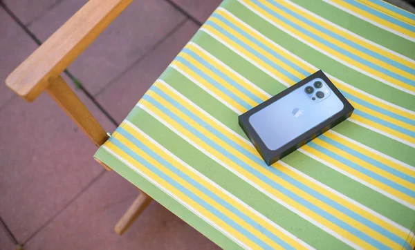 Terraço cadeira de madeira com novo pacote de papelão do iPhone 13 Pro Max 5G — Fotografia de Stock
