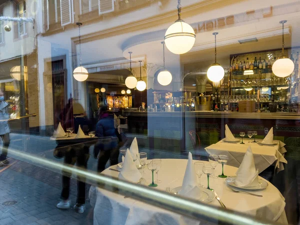 Walking in front of Flo restaurant with interior seen through glass window — Stock Photo, Image