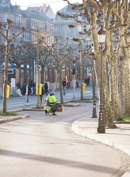 Sokak süpürücüsü elinde çöp torbalarıyla karşıdan karşıya geçiyor. — Stok fotoğraf