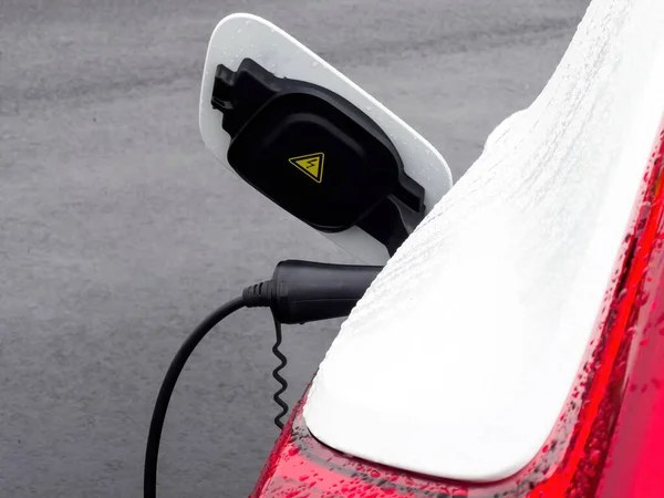 Σύγχρονο ηλεκτρικό αυτοκίνητο που φορτίζεται με καλώδιο τροφοδοσίας είναι plug on — Φωτογραφία Αρχείου