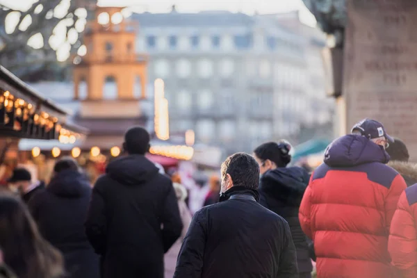 Soğuk ve dondurucu bir günde Noel pazarında yürüyen insanların arka görüntüsü. — Stok fotoğraf