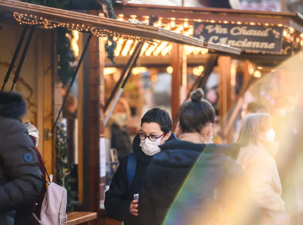 Donna che indossa maschere di protezione chirurgica respiratoria durante il mercatino di Natale di Place Broglie — Foto Stock