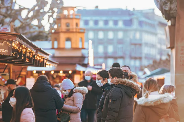 Large crowd of people wearing respiratory surgical protection masks during the Christmas market — Stockfoto