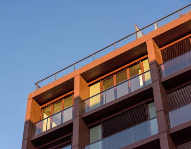 Arka planda açık mavi gökyüzü olan modern apartmanın düşük açılı görüntüsü