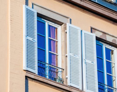 Mavi pencereli Fransız apartmanı UV ince film mavisi ile korunuyor.