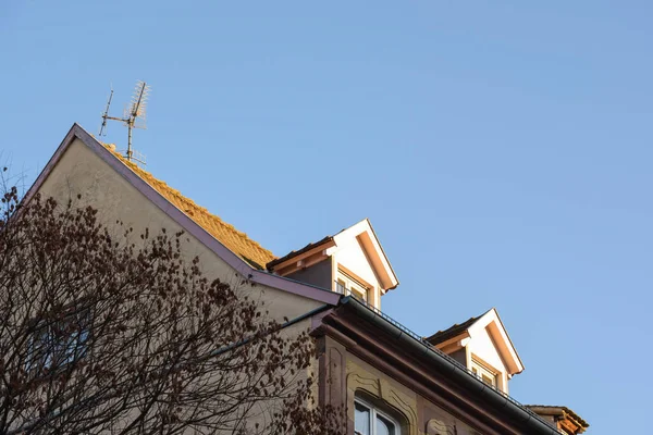 Mansard roof top windows and aerial antenna — Stock Photo, Image