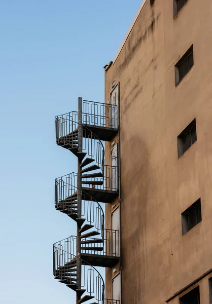 Escalier métallique de sécurité au coin du bâtiment avec ciel bleu — Photo