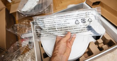 POV male hand holding plastic part of the new Roborock S6 robotic vacuum cleaner robovac during the unboxing process