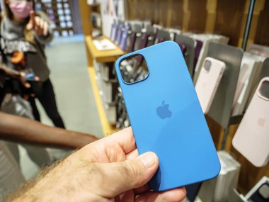 En son 5G iPhone 13, 13 Pro olarak Apple Store 'da silikon koruma çantası taşıyan POV erkek.