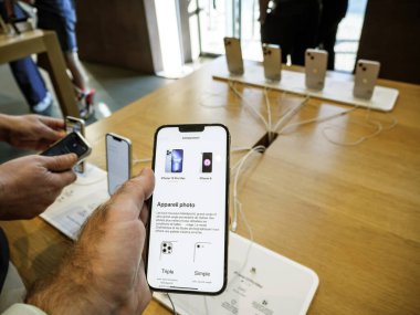 Male hand holding new silver iPhone 13 Pro Max smartphone