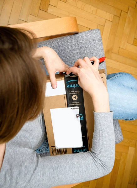 Overhead view of curious woman unboxing in the living room new Amazon Prime — стоковое фото