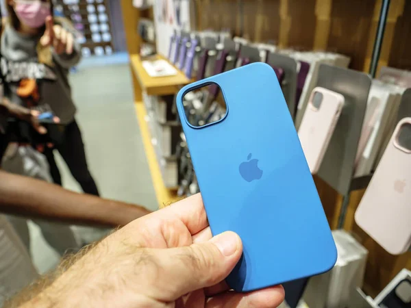 苹果专卖店的POV男性手持硅胶防护箱，作为最新的5G iPhone 13，13Pro — 图库照片