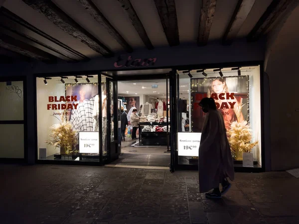 Silhouette of woman walking in front of clothing store with Black Frida — Photo