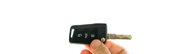 POV male hand holding new car key against green defocused backgr — ストック写真