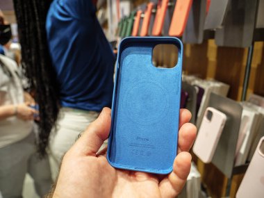 OV male hand holding blue silicone protection case of iPhone 13