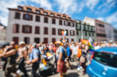 Defocused large crowd of participants at annual gay pride with f