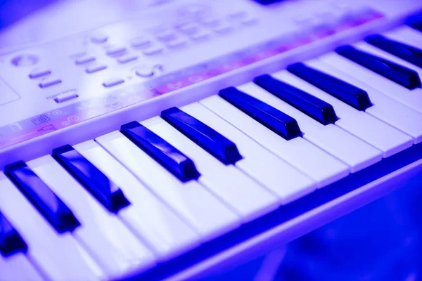 Blue color cast over keys of Yamaha on Remie digital keyboard PS — стоковое фото