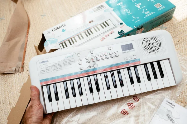 POV male hand unboxing new Yamaha Remie digital keyboard PSS-E30 — Zdjęcie stockowe