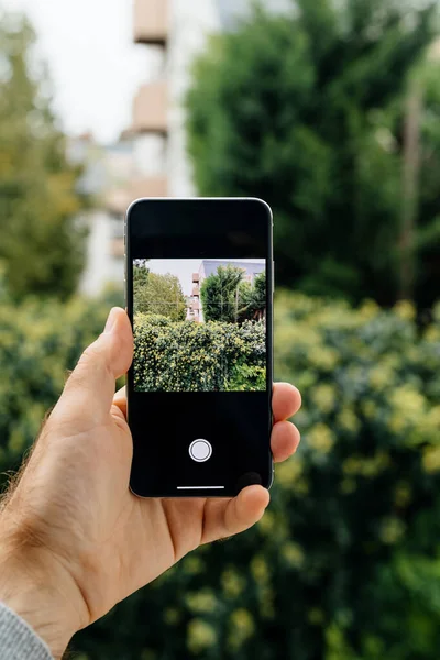 Male hand holding new Apple Computers iPhone SE smartphone takin — Stock fotografie