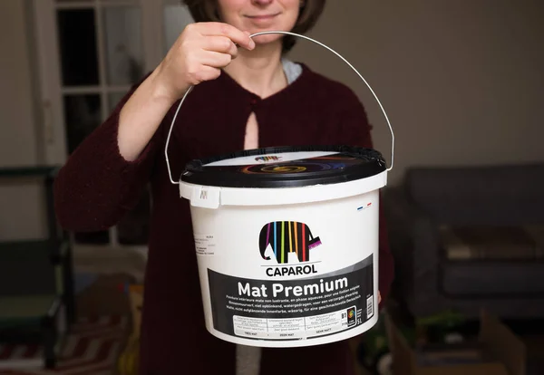 Young woman holding new plastic package bucket of Caparol Mat Premium — Fotografia de Stock